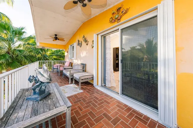 a balcony with wooden floor table and chairs