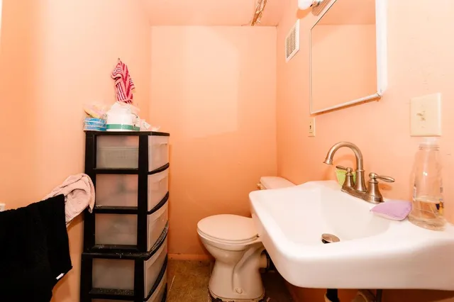 a bathroom with a toilet a sink and mirror