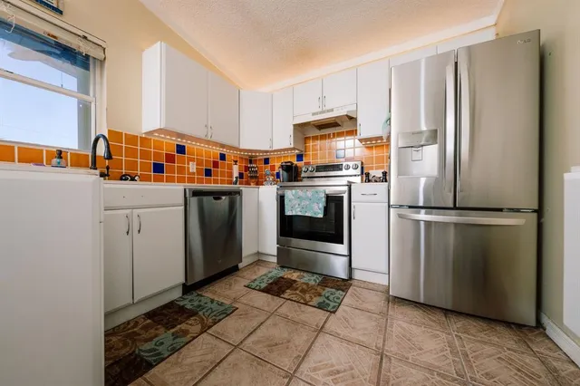 a kitchen with stainless steel appliances a refrigerator sink and microwave