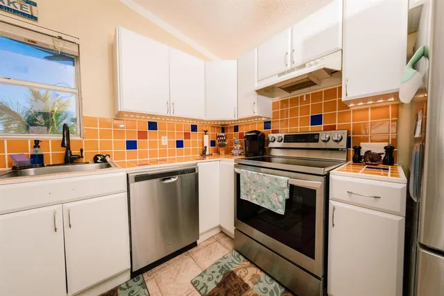 a kitchen with stainless steel appliances a stove a sink and a refrigerator