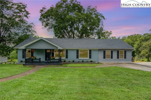 a front view of a house with a garden and trees