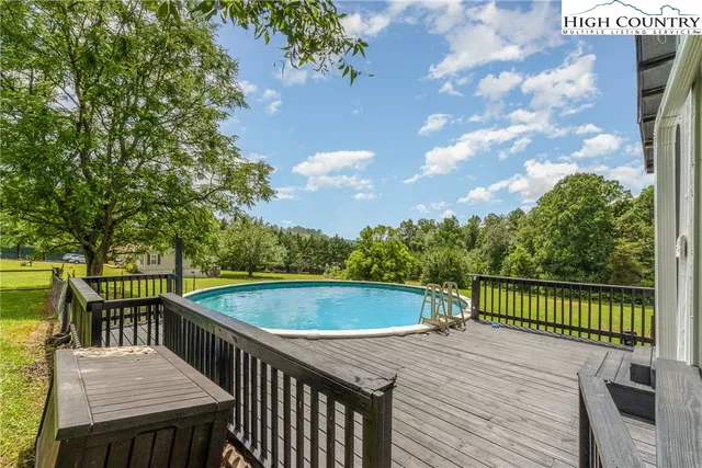 a view of a house with a yard and a large tree