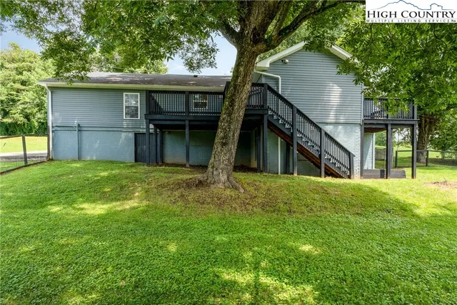 a view of a house with a backyard and a tree