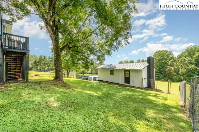 a view of a house with a big yard and large trees