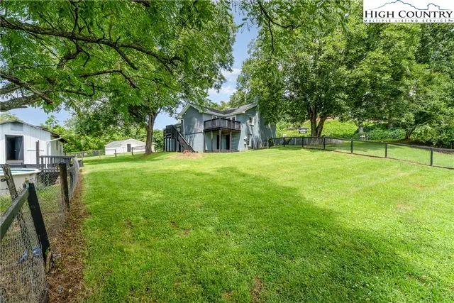a view of backyard of house with green space
