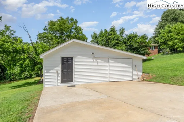 a view of an house with backyard and a tree