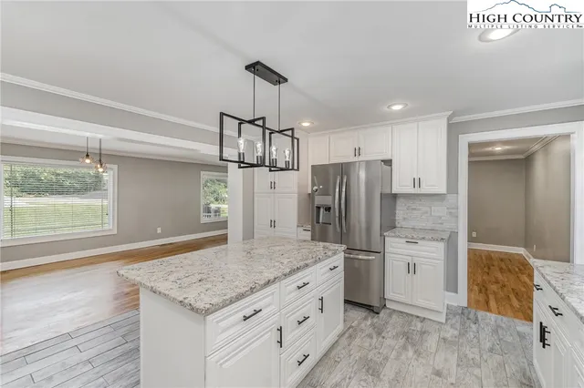 a kitchen with refrigerator cabinets and wooden floor