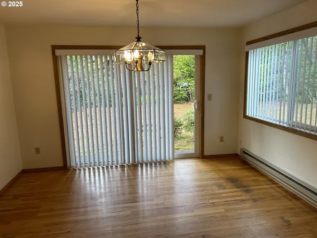 a view of a backyard with potted plants and large trees