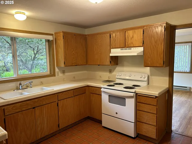 a kitchen with a sink cabinets and window