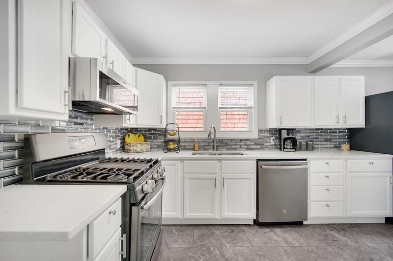 1012 177th Place Hammond, IN 46324 - Photo 7 of 26 a kitchen with stainless steel appliances a sink stove and cabinets
