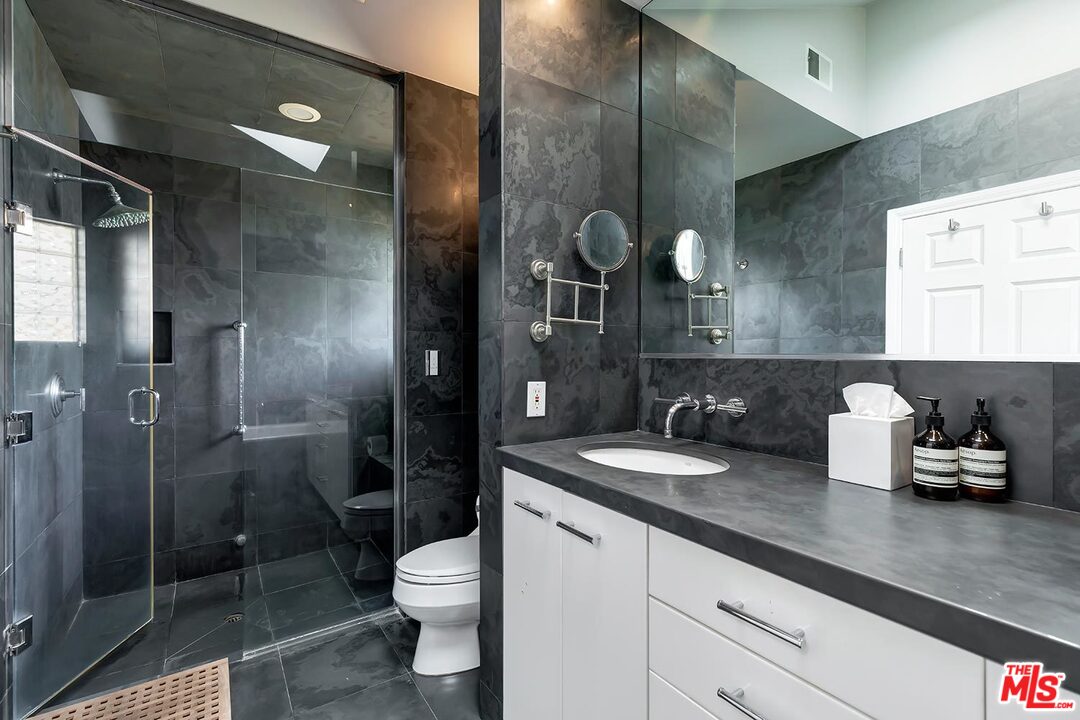 10629 Rountree Road Los Angeles, CA 90064 - Photo 24 of 37 a bathroom with a granite countertop sink a toilet a mirror and shower