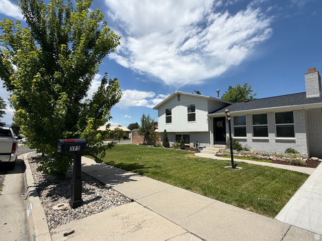 375 East 10560 South Sandy, UT 84070 - Photo 20 of 21 Split-level home featuring light-colored brick and siding, a dark shingle roof, and a prominent chimney