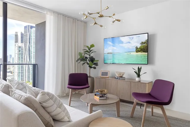 a living room with furniture a chandelier and a rug