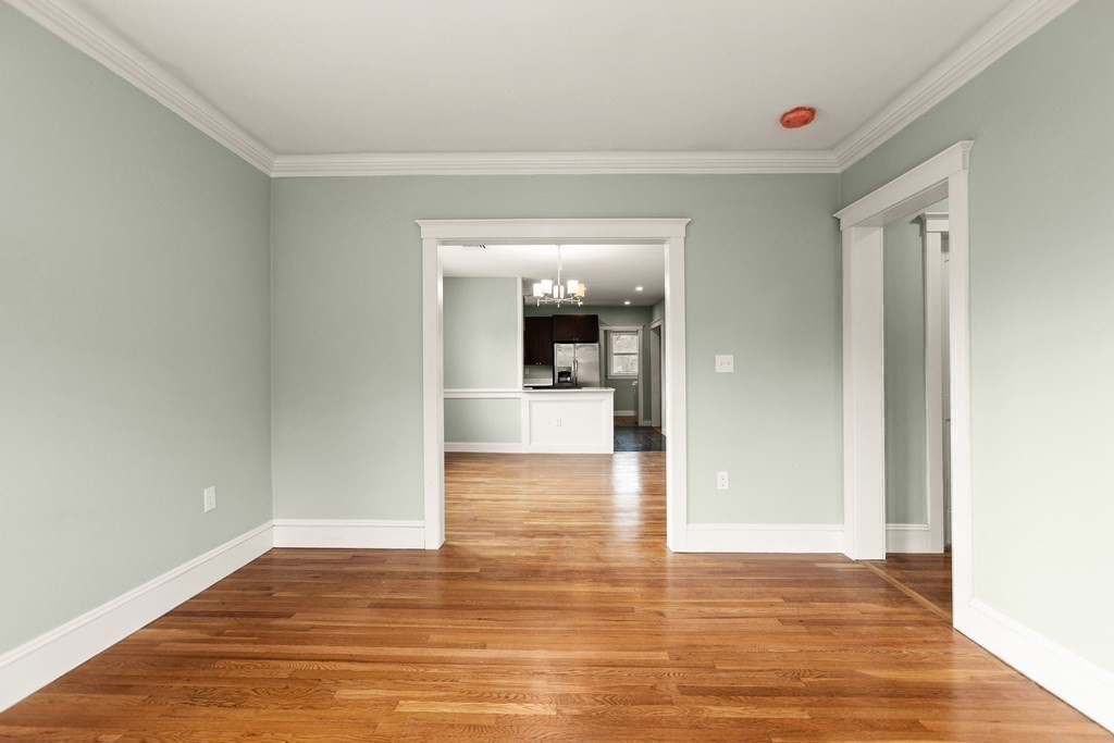 564 Lagrange Street, Unit 2 Boston, MA 02132 - Photo 11 of 27 a view of a hallway with wooden floor and a kitchen