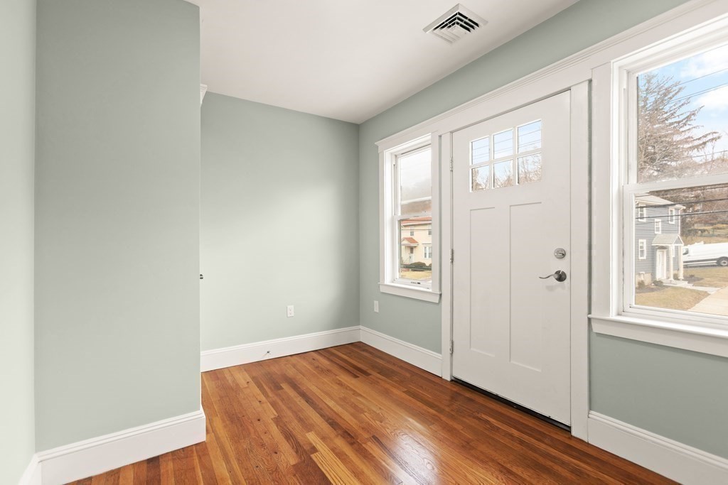 564 Lagrange Street, Unit 2 Boston, MA 02132 - Photo 15 of 27 an empty room with wooden floor and windows