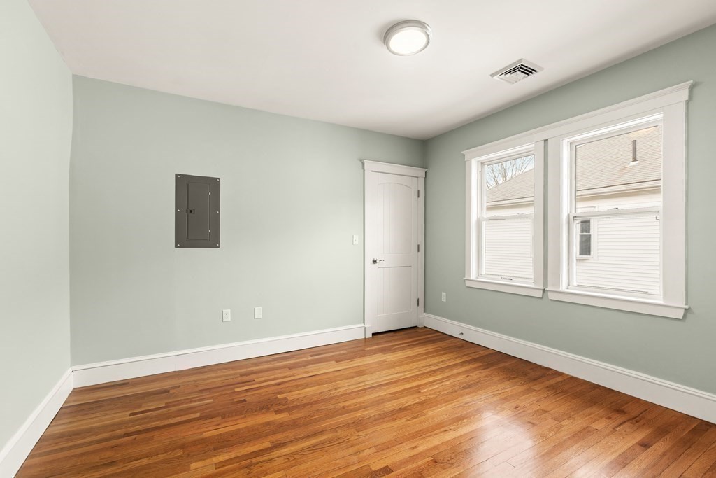 564 Lagrange Street, Unit 2 Boston, MA 02132 - Photo 16 of 27 an empty room with wooden floor and windows