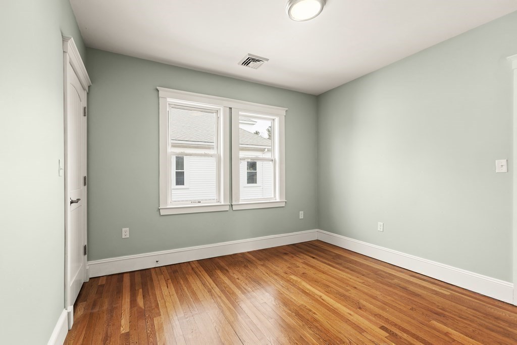 564 Lagrange Street, Unit 2 Boston, MA 02132 - Photo 17 of 27 an empty room with wooden floor and windows