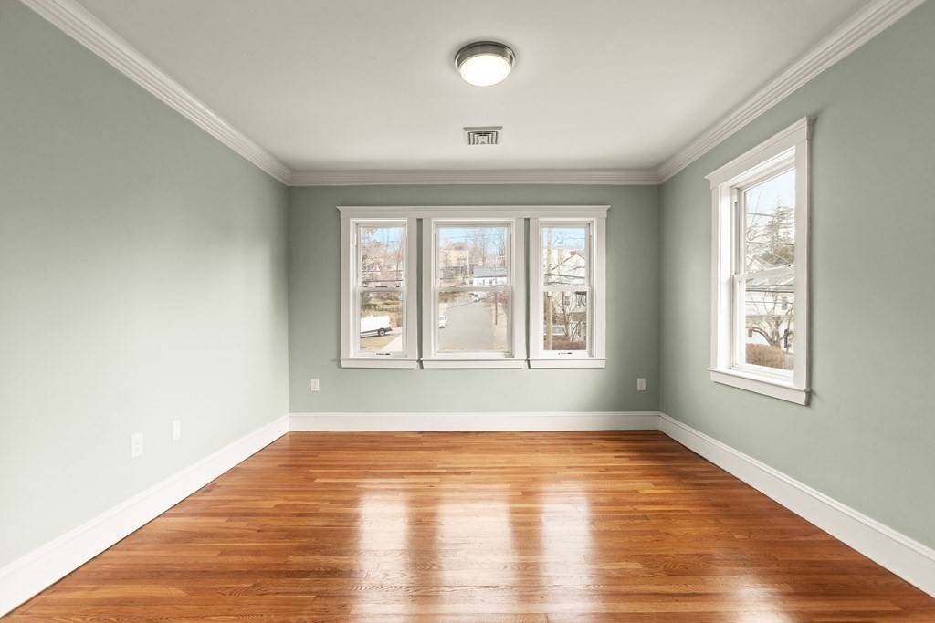 564 Lagrange Street, Unit 2 Boston, MA 02132 - Photo 18 of 27 a view of an empty room with wooden floor and a window