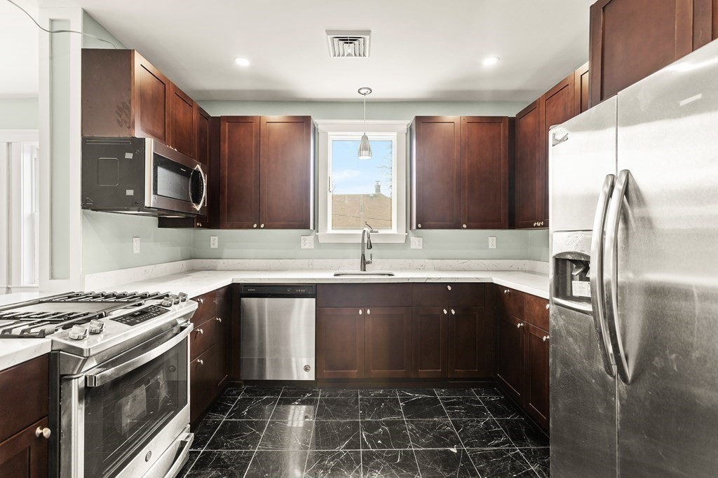 564 Lagrange Street, Unit 2 Boston, MA 02132 - Photo 2 of 27 a kitchen with stainless steel appliances granite countertop a sink stove and refrigerator