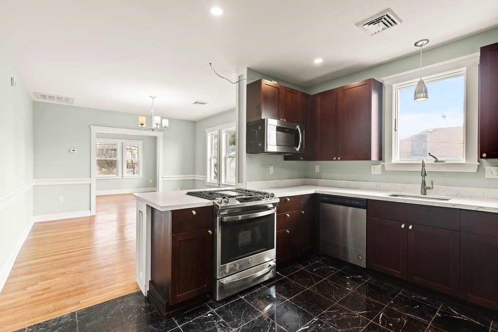 564 Lagrange Street, Unit 2 Boston, MA 02132 - Photo 3 of 27 a kitchen with stainless steel appliances granite countertop a sink stove and cabinets