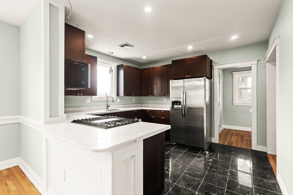 564 Lagrange Street, Unit 2 Boston, MA 02132 - Photo 6 of 27 a kitchen with stainless steel appliances granite countertop a sink stove and refrigerator