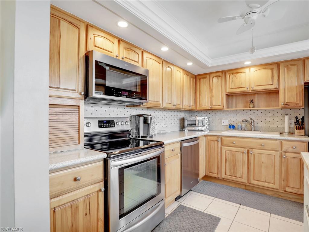 119 Harrison Road, Unit 16 Naples, FL 34112 - Photo 4 of 26 Kitchen with stainless steel appliances, light brown cabinetry, ornamental molding, recessed lighting, and backsplash