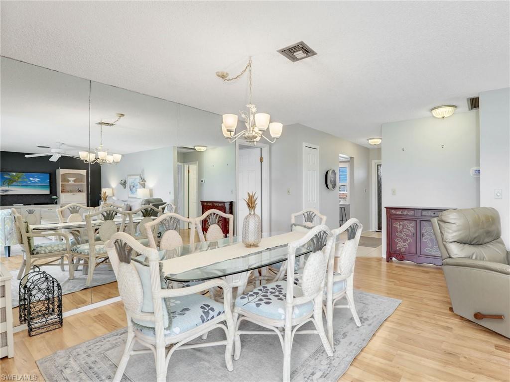 119 Harrison Road, Unit 16 Naples, FL 34112 - Photo 10 of 26 Dining space featuring a chandelier and light wood-style floors