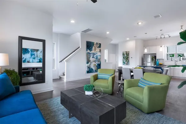 a living room with furniture and a wooden floor