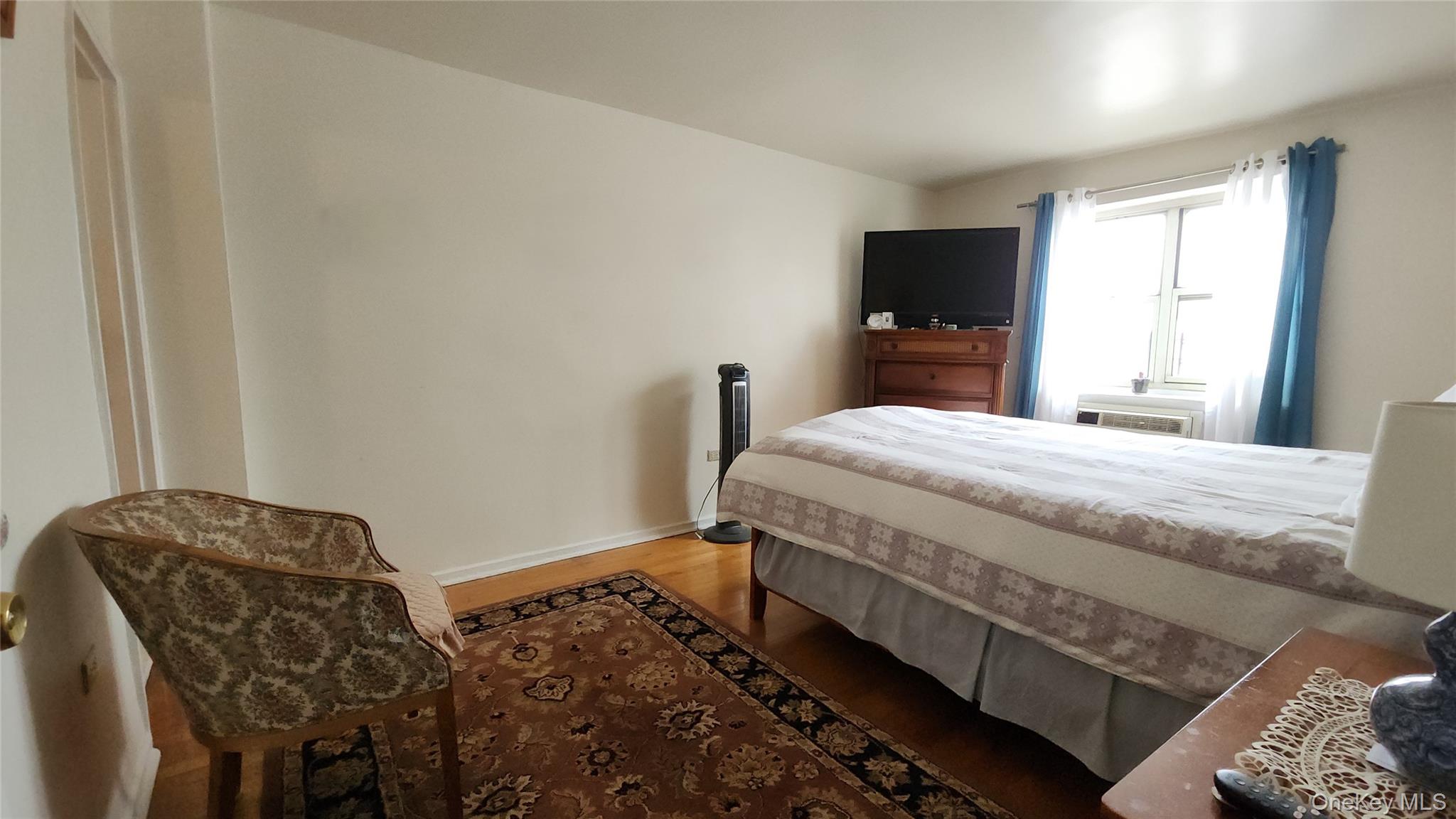 99-10 60th Avenue, Unit 3H Queens, NY 11368 - Photo 12 of 25 a bedroom with a bed and a tv