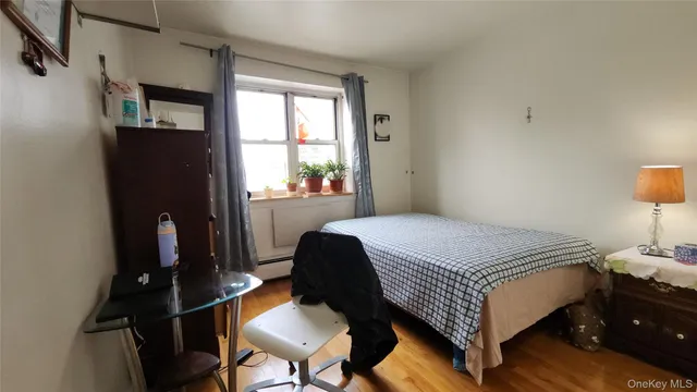 a bedroom with a bed dresser and a window