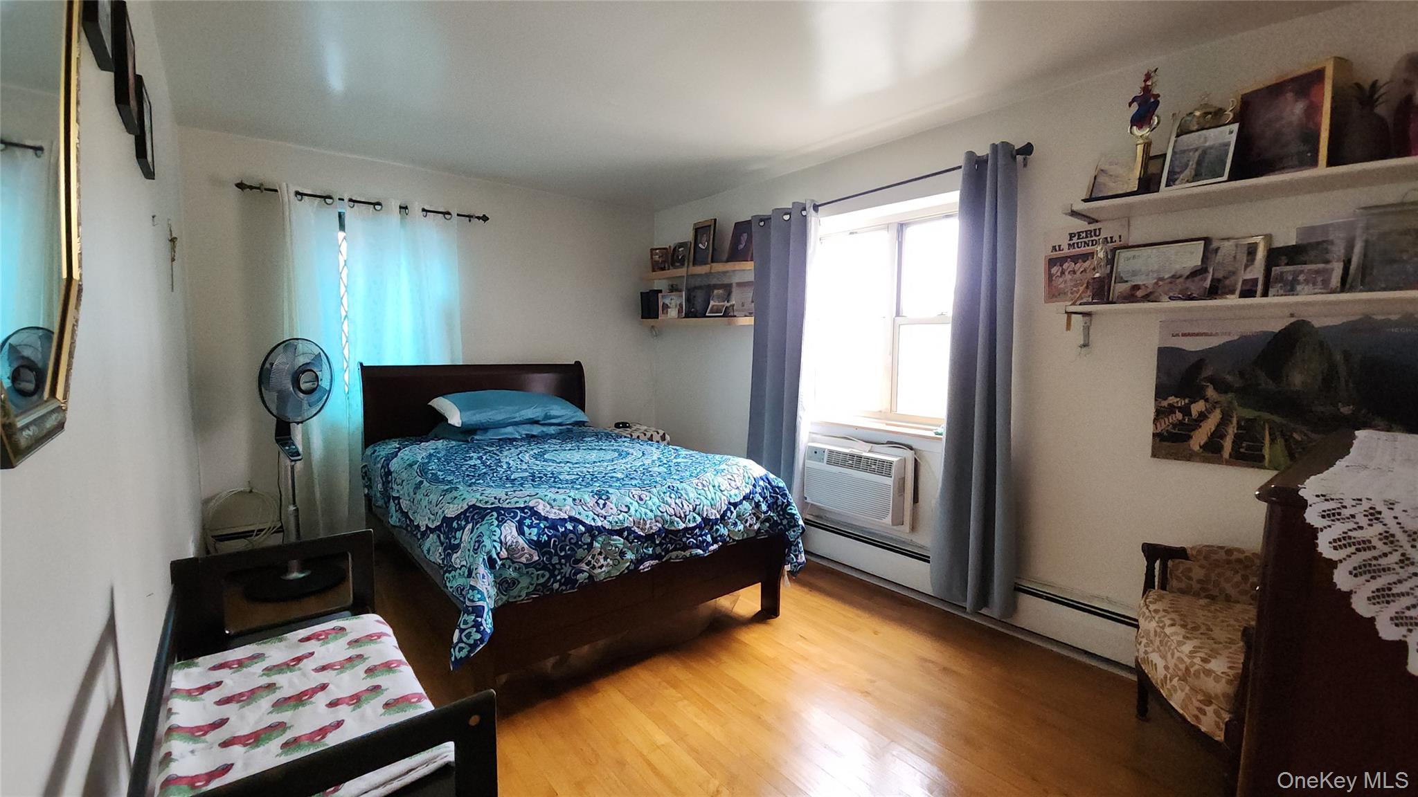 99-10 60th Avenue, Unit 3H Queens, NY 11368 - Photo 18 of 25 a bedroom with a bed and wooden floor