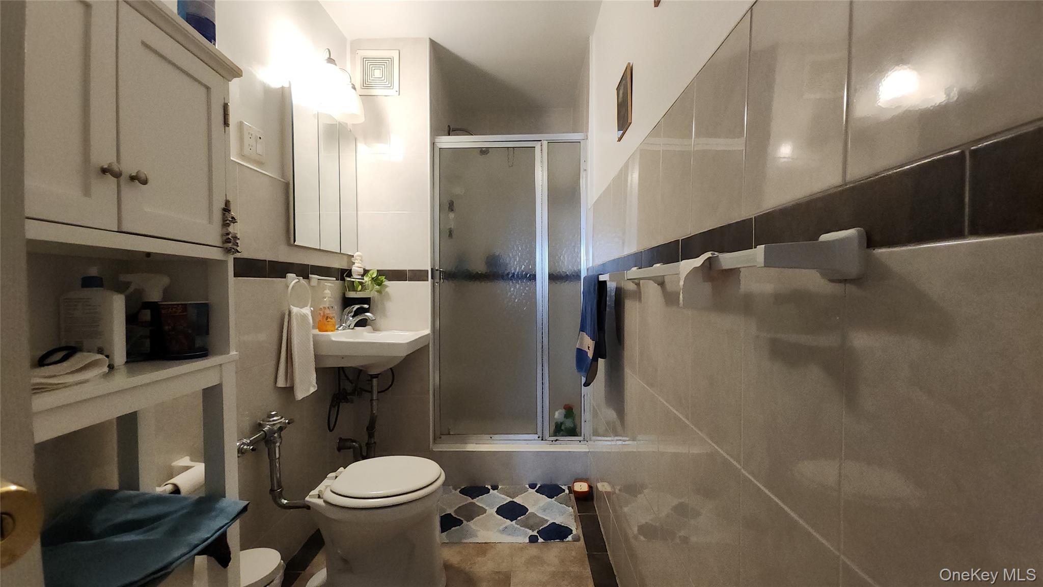 99-10 60th Avenue, Unit 3H Queens, NY 11368 - Photo 5 of 25 a bathroom with a sink toilet and shower