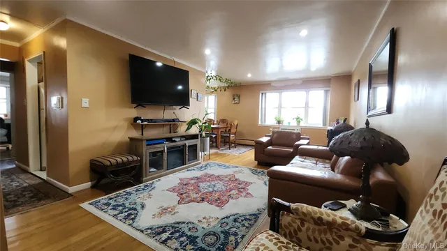 a living room with furniture a flat screen tv and a window