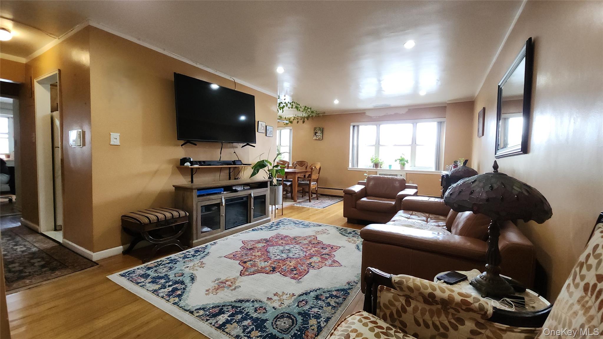 99-10 60th Avenue, Unit 3H Queens, NY 11368 - Photo 6 of 25 a living room with furniture and a flat screen tv