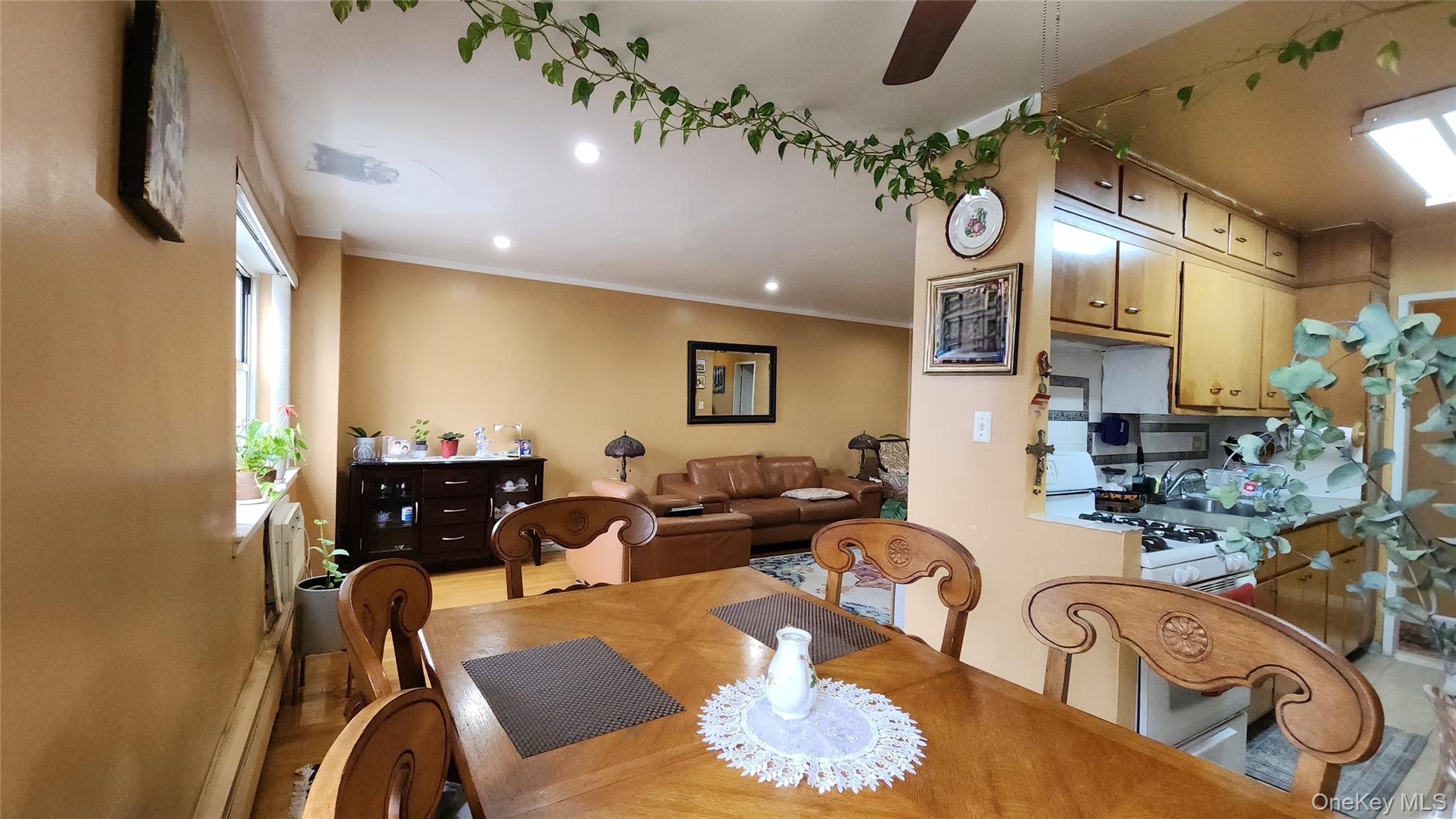 99-10 60th Avenue, Unit 3H Queens, NY 11368 - Photo 10 of 25 a living room with furniture kitchen view and a chandelier