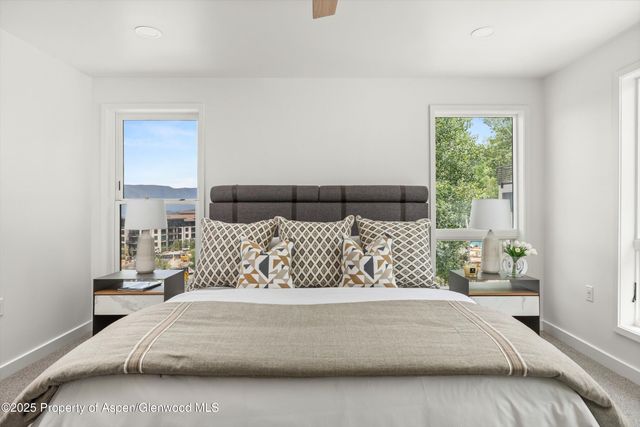 a large bed sitting in a bedroom next to a window