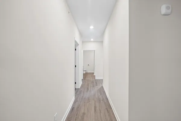 a view of a hallway with wooden floor
