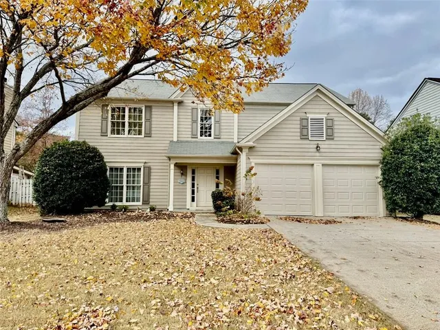 a front view of a house with a yard covered in snow