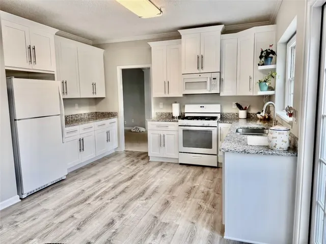 a kitchen with white cabinets and white appliances