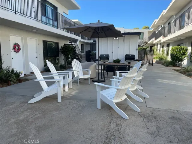 a view of a patio with a table and chairs under an umbrella