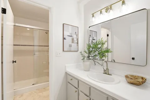 a bathroom with a granite countertop shower sink and toilet