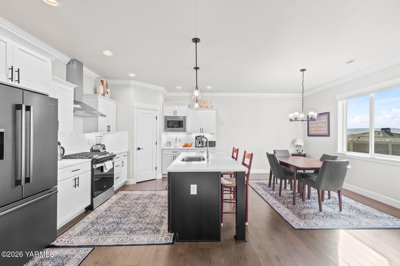 304 Rainier Street Yakima, WA 98908 - Photo 23 of 39 a kitchen with stainless steel appliances granite countertop a stove refrigerator and a dining table with wooden floor