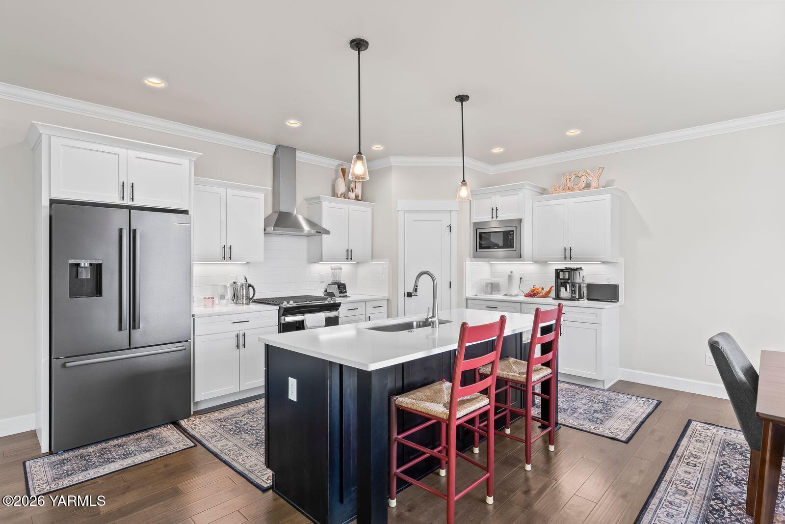 304 Rainier Street Yakima, WA 98908 - Photo 24 of 39 a kitchen with stainless steel appliances granite countertop a stove a refrigerator a kitchen island a dining table and chairs