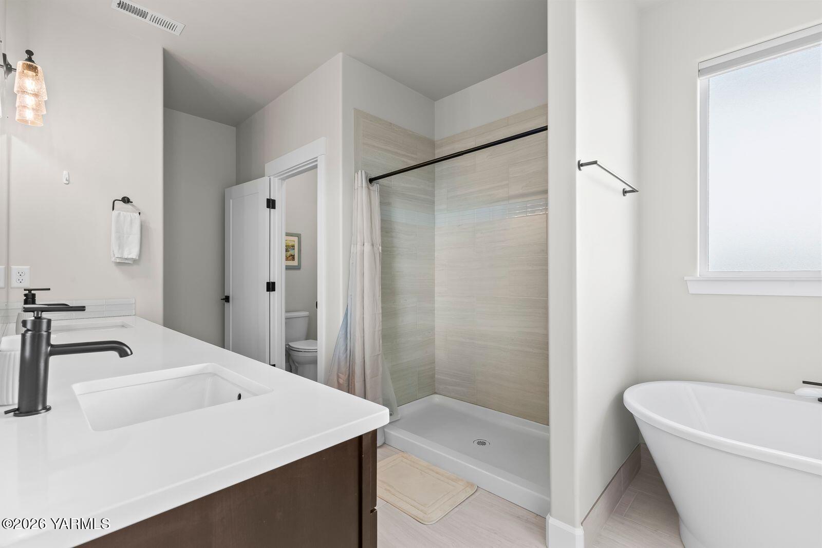 304 Rainier Street Yakima, WA 98908 - Photo 32 of 39 a bathroom with a tub a sink and a large mirror