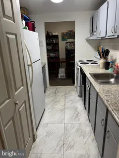 a kitchen with refrigerator and cabinets
