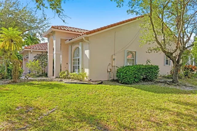 a view of a house with a big yard and large tree