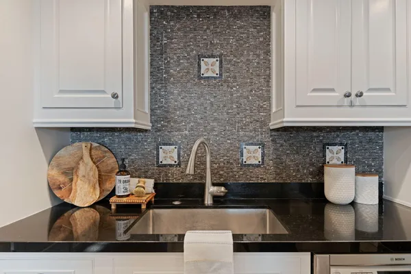 a kitchen with a sink and a stove with wooden floor