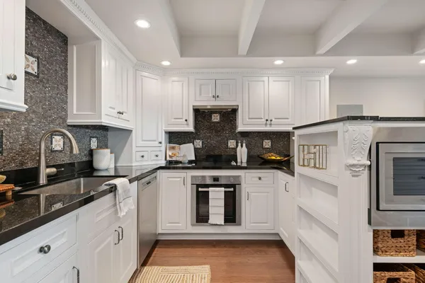 a kitchen with kitchen island granite countertop a stove sink and cabinets