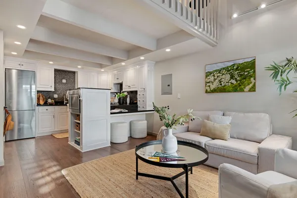 a living room with furniture kitchen view and a refrigerator