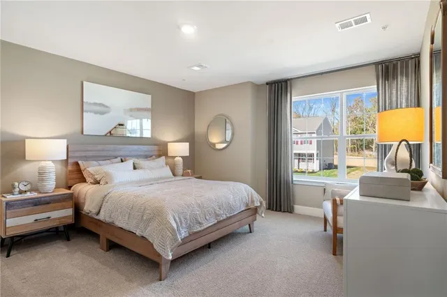 a bedroom with a bed wooden floor and a large window